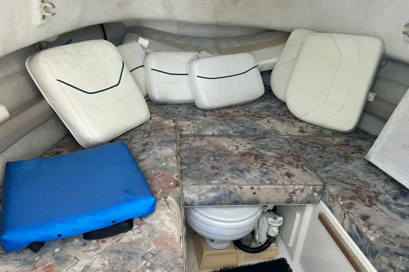 Slide: The Image of Interior cabin of a 2000 Pursuit 2470 Walkaround boat with cushions and a compact toilet. - 17