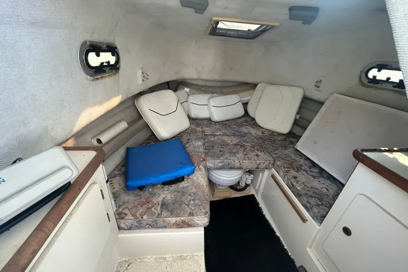 Slide: The Image of 2000 Pursuit 2470 Walkaround cabin interior with cushions and compact layout. - 18