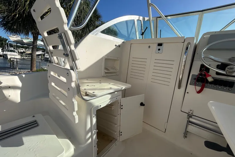 Slide: The Image of 2000 Pursuit 2470 Walkaround boat interior with seating and storage compartments. - 24