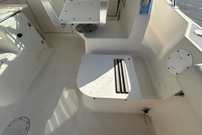 Slide: The Image of 2000 Pursuit 2470 Walkaround boat interior with seating and storage compartments. - 25