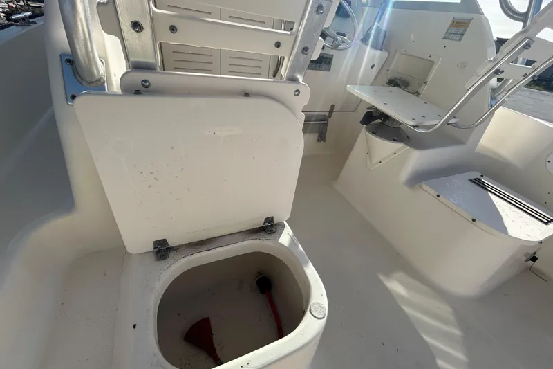 Slide: The Image of 2000 Pursuit 2470 Walkaround boat interior with open storage compartment. - 28