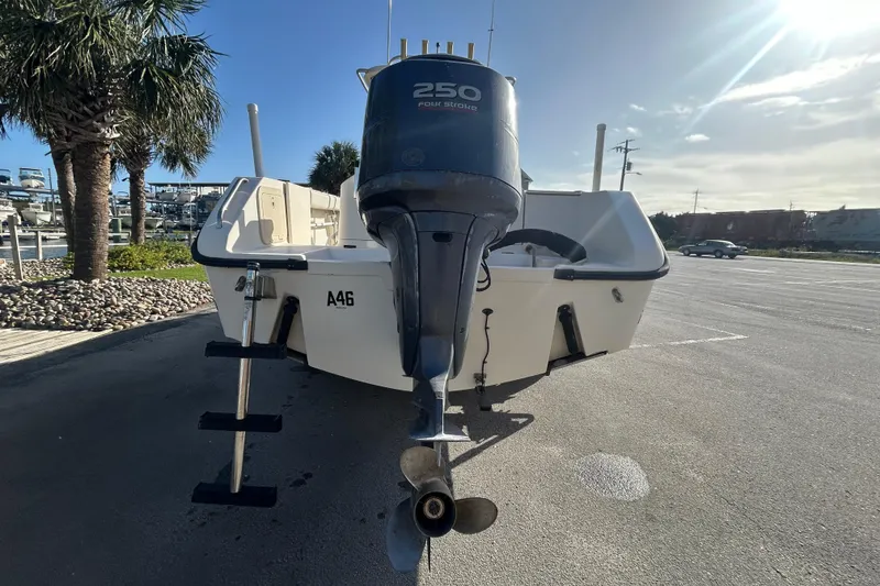 Slide: The Image of 2000 Pursuit 2470 Walkaround boat with 250 horsepower outboard motor in a sunny marina. - 4