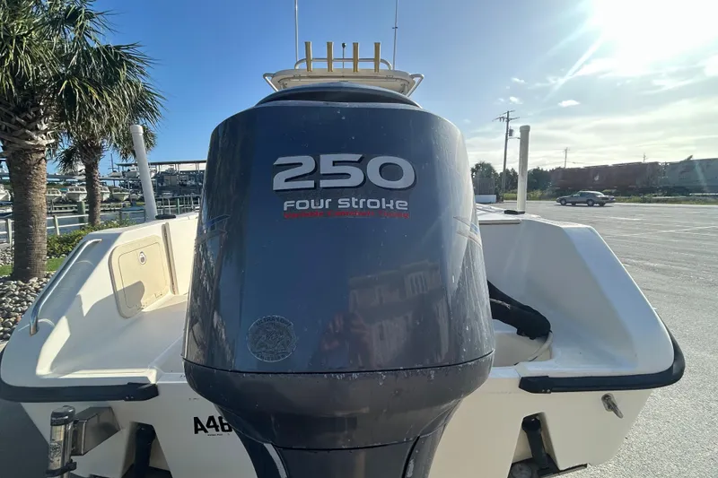Slide: The Image of 2000 Pursuit 2470 Walkaround boat with 250 four-stroke engine in sunny marina setting. - 5