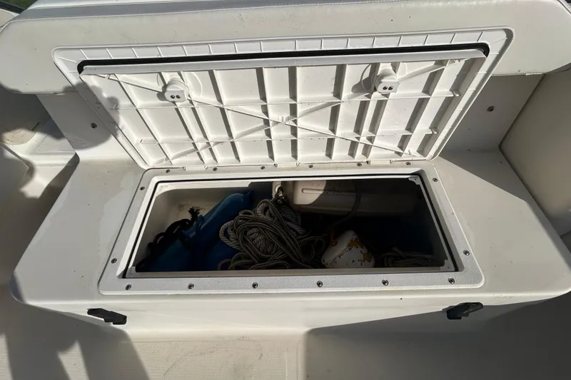 Slide: The Image of Storage compartment on a 2000 Pursuit 2470 Walkaround boat, containing ropes and equipment. - 8