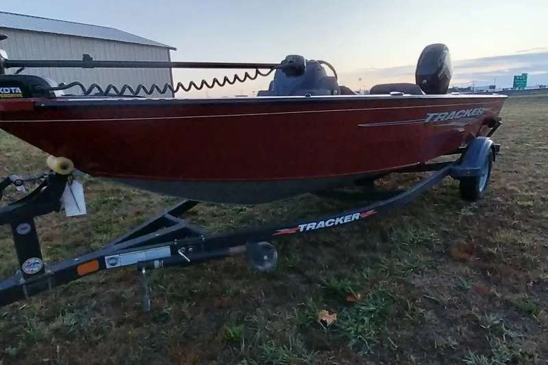 Slide: The Image of 2021 Tracker Super Guide V-16 SC boat on trailer, parked on grass at sunset. - 10