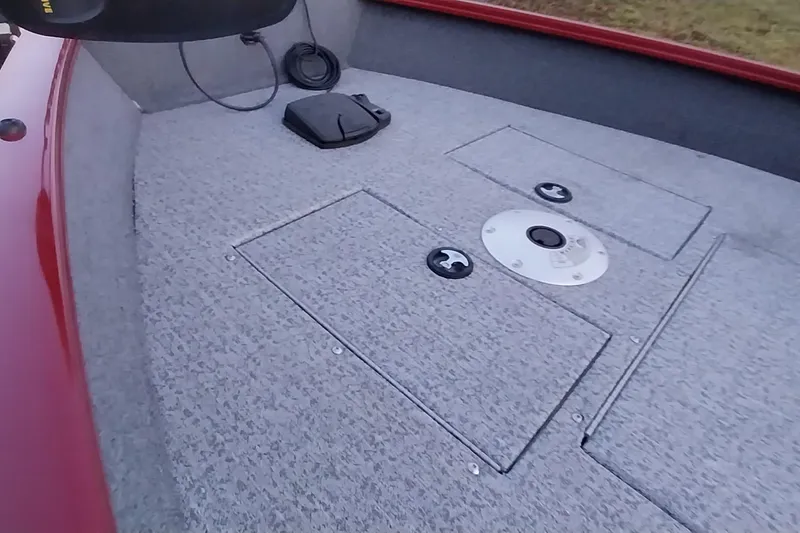 Slide: The Image of 2021 Tracker Super Guide V-16 SC boat deck with storage compartments and red trim. - 16