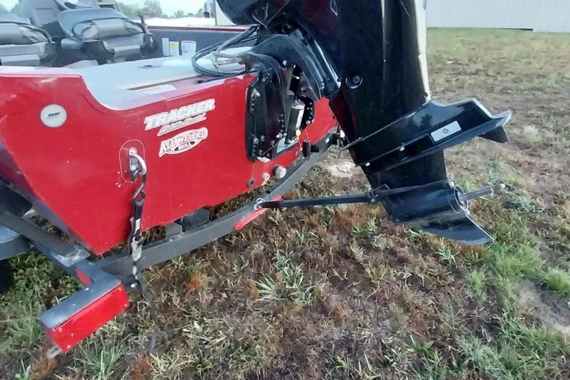 Slide: The Image of 2021 Tracker Super Guide V-16 SC boat rear view with motor on grassy terrain. - 29