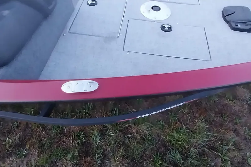 Slide: The Image of 2021 Tracker Super Guide V-16 SC boat deck with red trim on grassy surface. - 3