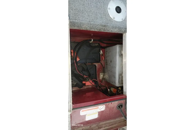 Slide: The Image of 2021 Tracker Super Guide V-16 SC boat battery compartment with wiring and components. - 34