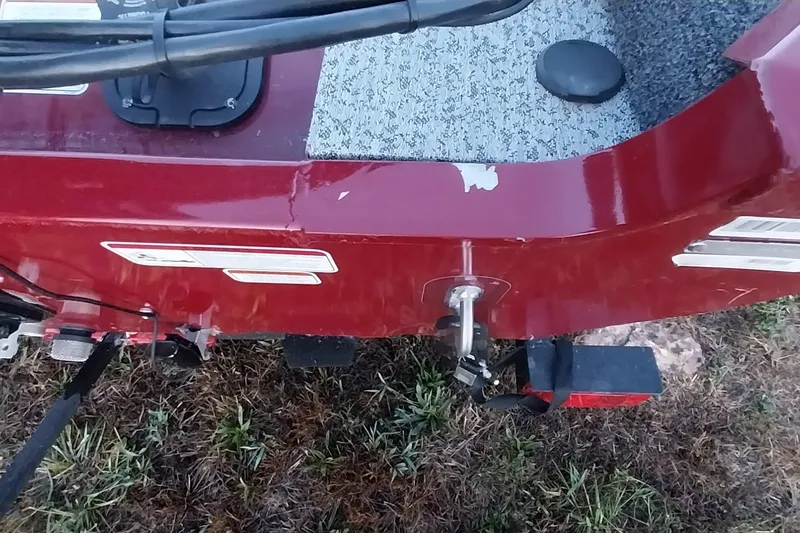 Slide: The Image of 2021 Tracker Super Guide V-16 SC boat, red exterior, close-up view on grass. - 40