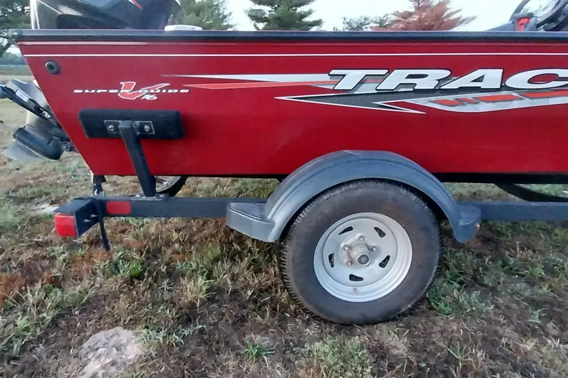 Slide: The Image of 2021 Tracker Super Guide V-16 SC boat on trailer, red exterior, parked on grass. - 41