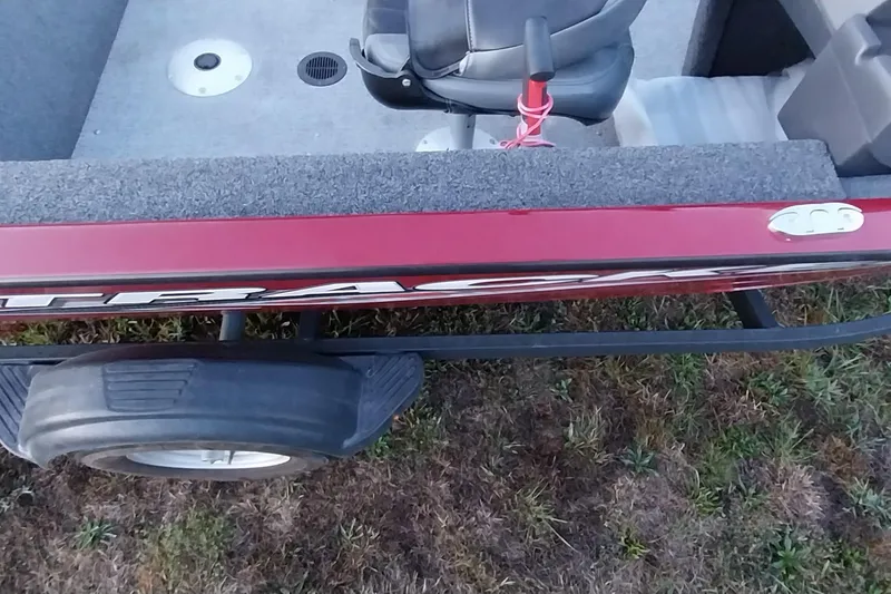 Slide: The Image of 2021 Tracker Super Guide V-16 SC boat on trailer, red exterior, gray interior, grassy background. - 45