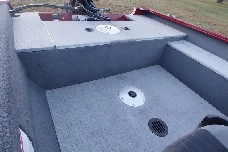 Slide: The Image of 2021 Tracker Super Guide V-16 SC boat interior with gray carpeted deck and storage compartments. - 47