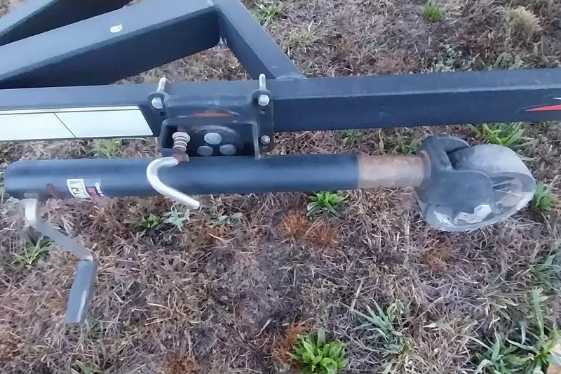 Slide: The Image of Trailer jack on 2021 Tracker Super Guide V-16 SC, resting on grassy ground. - 9