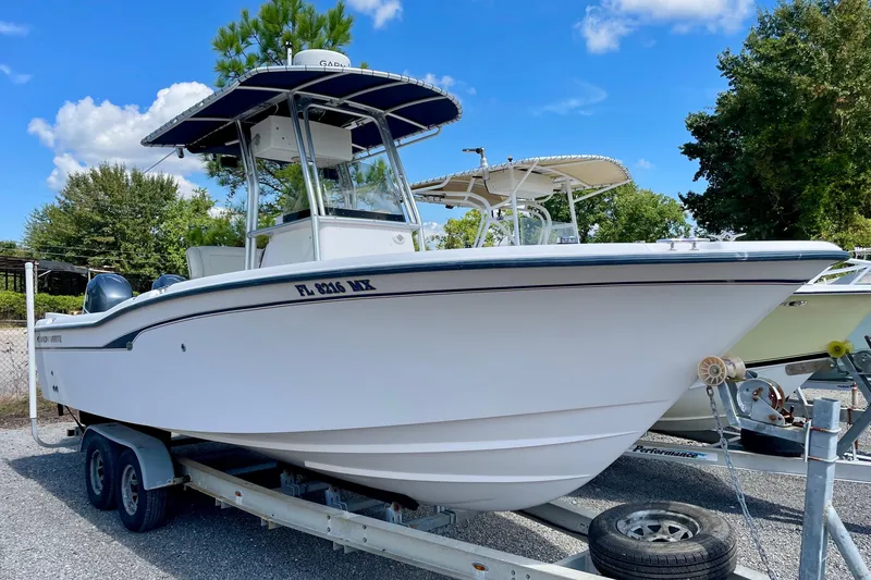 Slide: The Image of 2004 Grady-White Advance 257 boat on trailer, parked outdoors under blue sky. - 2