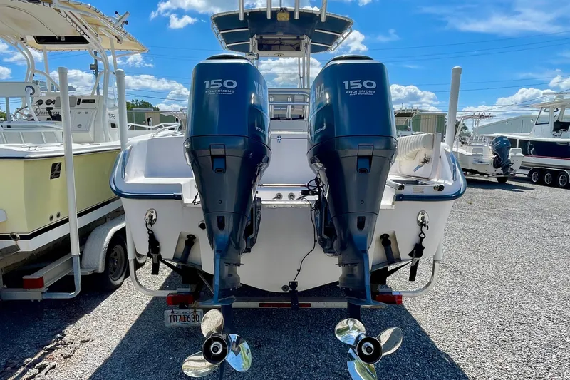 Slide: The Image of 2004 Grady-White Advance 257 boat with dual Yamaha 150 engines, parked on gravel. - 7