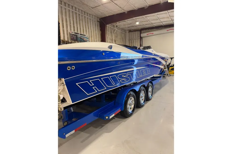 Slide: The Image of Blue 2016 Hustler 39 boat on trailer in indoor storage facility. - 0