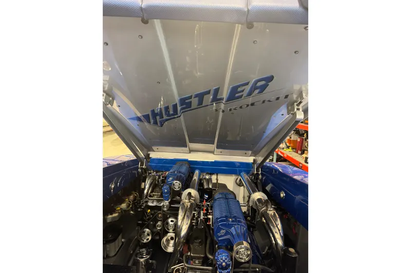 Slide: The Image of Engine compartment of a 2016 Hustler 39 boat, showcasing powerful machinery and branding. - 13