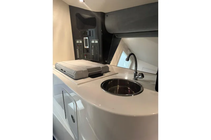 Slide: The Image of Interior of 2016 Hustler 39 boat featuring a compact sink and control panel. - 20