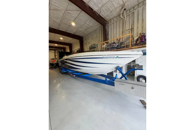 Slide: The Image of 2016 Hustler 39 boat on trailer in spacious indoor storage facility. - 5