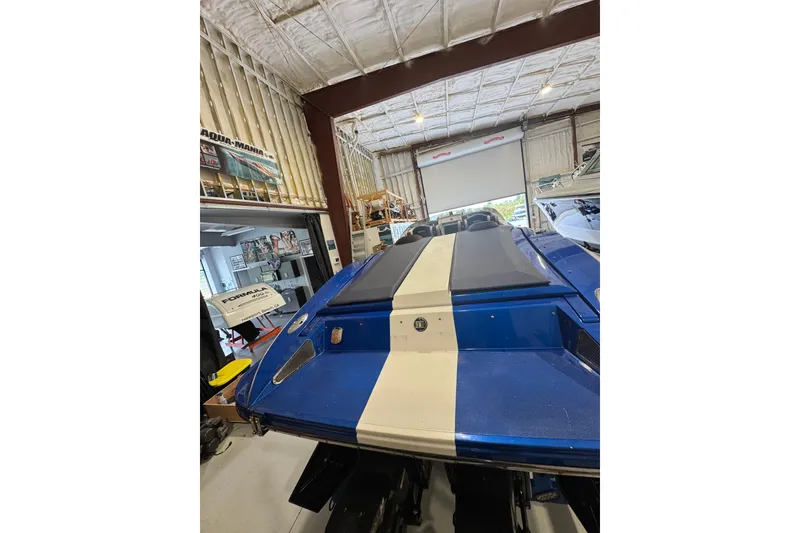 Slide: The Image of 2016 Hustler 39 boat in a garage, featuring a blue and white design. - 6