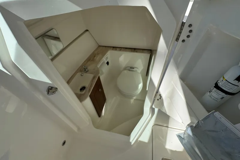 Slide: The Image of 2022 Pursuit DC 266 Dual Console boat interior with compact bathroom amenities. - 13