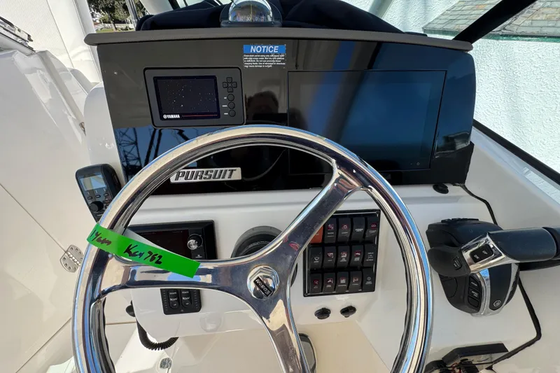 Slide: The Image of 2022 Pursuit DC 266 Dual Console boat dashboard with steering wheel and control panel. - 16