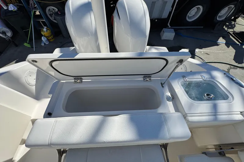 Slide: The Image of 2022 Pursuit DC 266 Dual Console boat with open storage compartment and sink. - 17