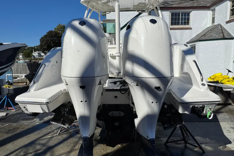 Slide: The Image of 2022 Pursuit DC 266 Dual Console boat with twin Yamaha outboard engines, docked outdoors. - 2