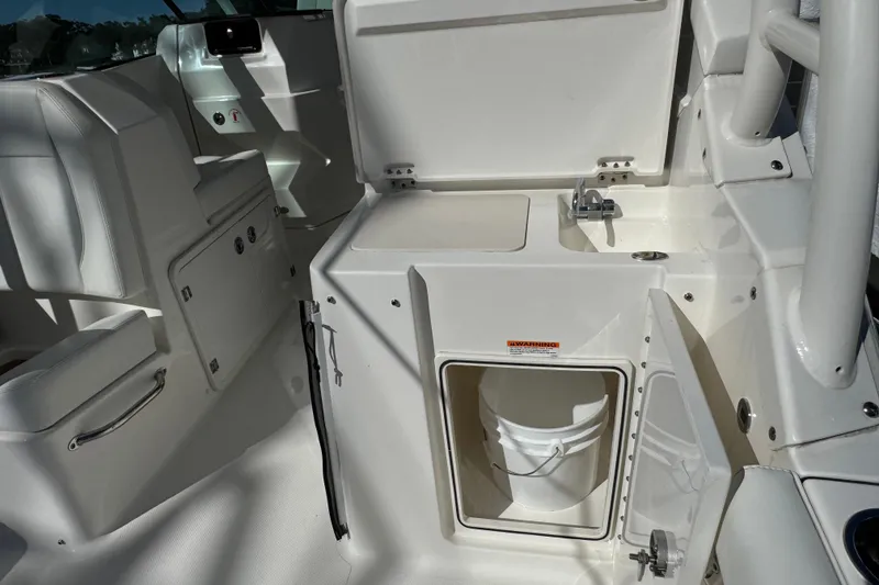 Slide: The Image of 2022 Pursuit DC 266 Dual Console boat interior with sink and storage compartment. - 5