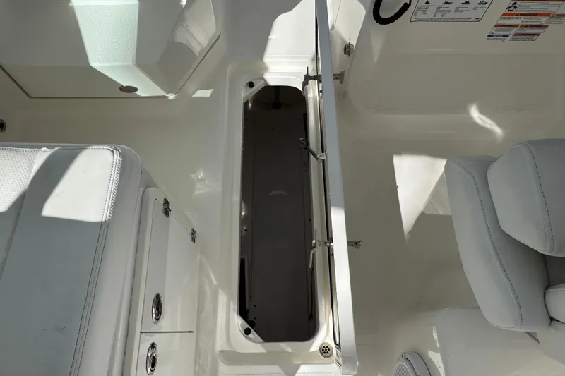 Slide: The Image of 2022 Pursuit DC 266 Dual Console boat interior with open storage compartment. - 6