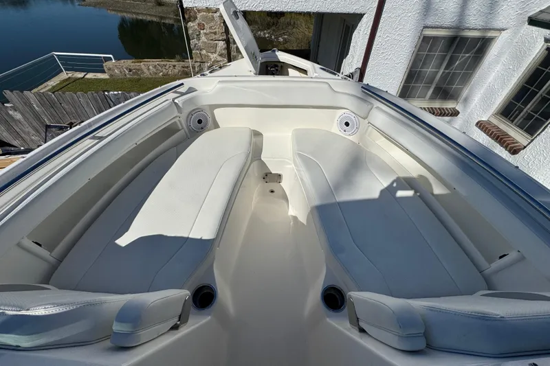 Slide: The Image of 2022 Pursuit DC 266 Dual Console boat interior with white seating and waterfront view. - 9