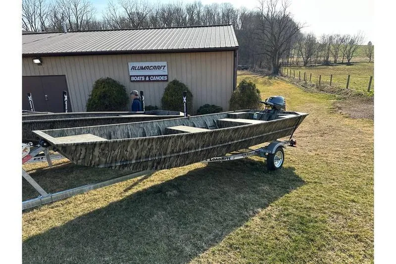 The Image of 2025 Smoker Craft 1648 Jon boat on trailer outside Alumacraft dealership. - 1