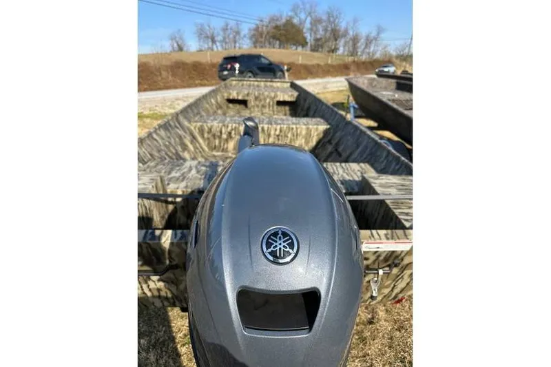 Slide: The Image of 2025 Smoker Craft 1648 Jon boat with Yamaha outboard motor, parked outdoors. - 5