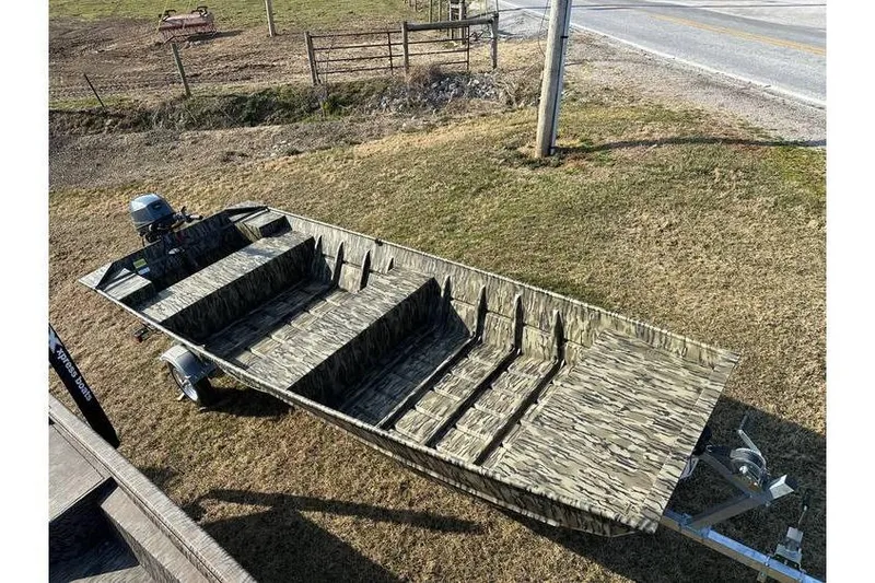 Slide: The Image of 2025 Smoker Craft 1648 Jon boat with camouflage design on a grassy area. - 7