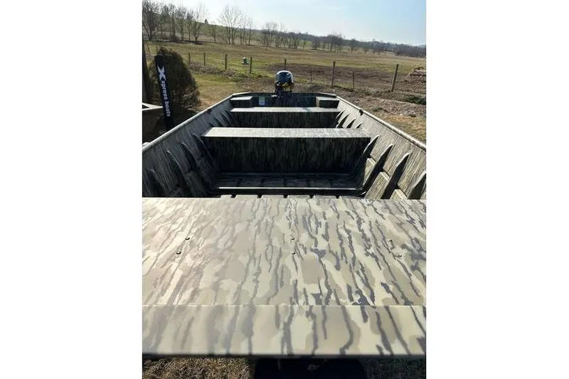 Slide: The Image of 2025 Smoker Craft 1648 Jon boat with camouflage interior, parked outdoors. - 8