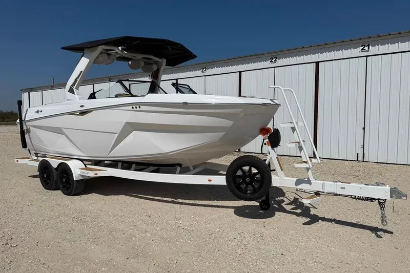 Slide: The Image of 2026 Tigé Z3 boat on trailer, parked outdoors near storage units. - 1