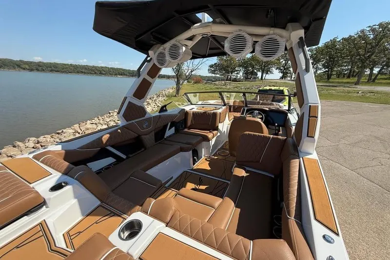 Slide: The Image of 2026 Tigé Z3 boat interior with luxurious brown seating and modern design by a lakeside. - 5