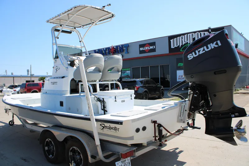 Slide: The Image of 2020 Shoalwater 21 Catamaran with Suzuki outboard motor on trailer, parked outside dealership. - 14