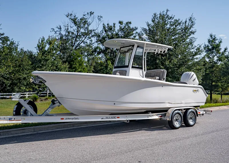 The Image of 2026 Sea Hunt Ultra 245 SE boat on trailer, parked on roadside. - 1