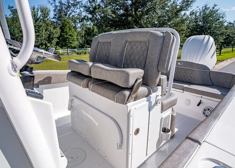 Slide: The Image of 2026 Sea Hunt Ultra 245 SE boat interior with cushioned seating and steering console. - 17