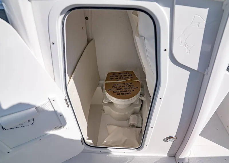 Slide: The Image of 2026 Sea Hunt Ultra 245 SE boat interior with compact marine toilet. - 18
