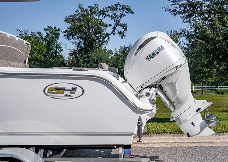 Slide: The Image of 2026 Sea Hunt Ultra 245 SE boat with Yamaha outboard motor, parked outdoors. - 3