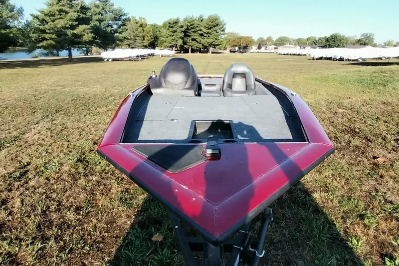 Slide: The Image of 2024 Tracker Pro Team 175 TXW boat on grassy field, surrounded by trees. - 13