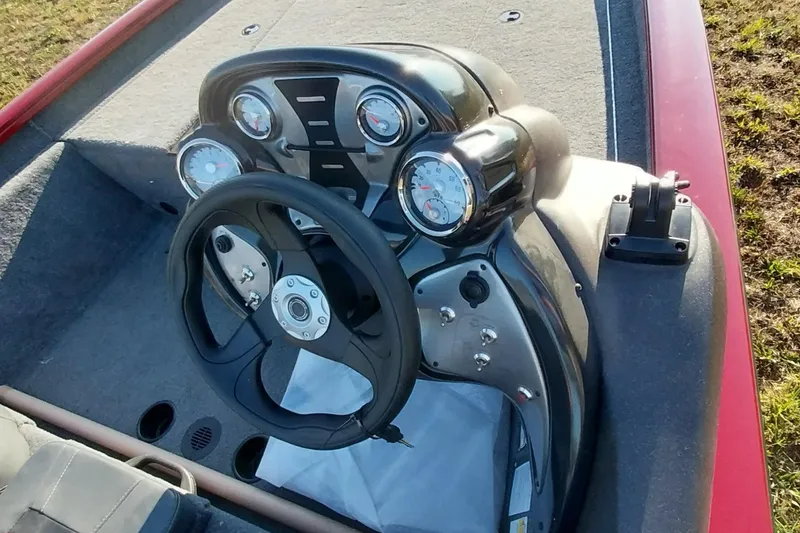 Slide: The Image of 2024 Tracker Pro Team 175 TXW boat dashboard with steering wheel and gauges. - 2