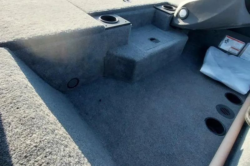 Slide: The Image of 2024 Tracker Pro Team 175 TXW boat interior with carpeted flooring and cup holders. - 24