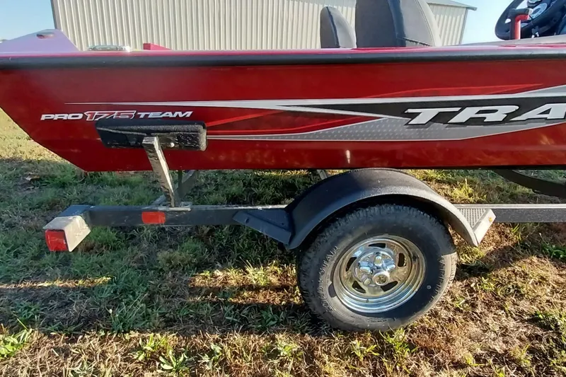 Slide: The Image of 2024 Tracker Pro Team 175 TXW boat on trailer, red exterior, parked on grass. - 32
