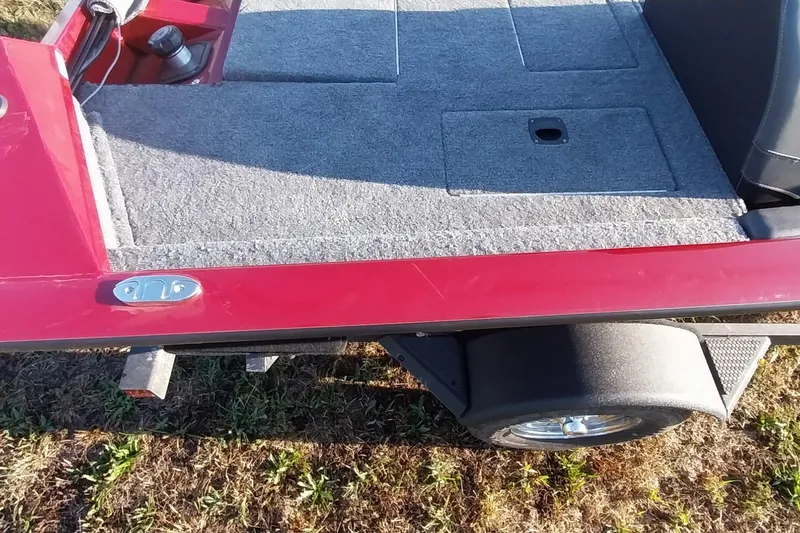 Slide: The Image of 2024 Tracker Pro Team 175 TXW boat, red exterior, gray carpeted deck, on trailer. - 33