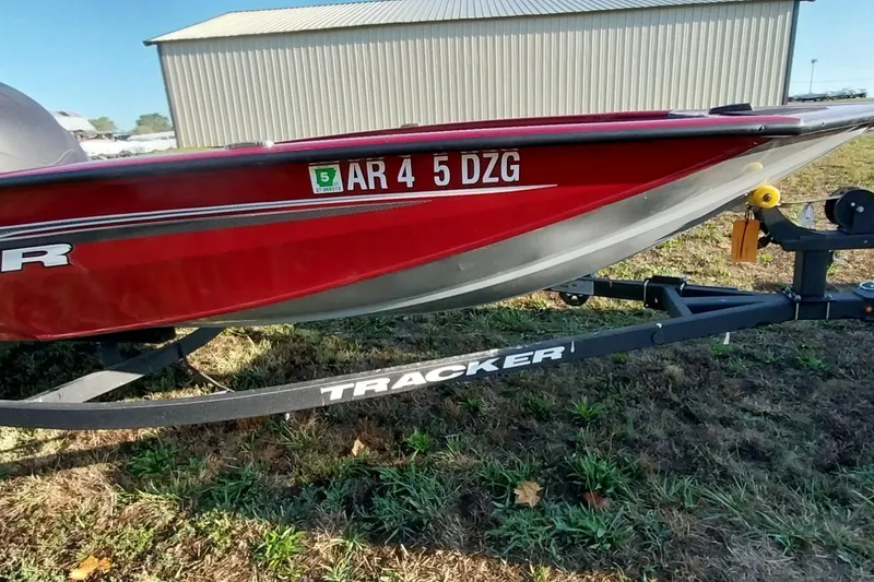 Slide: The Image of 2024 Tracker Pro Team 175 TXW boat on trailer, red hull, parked outdoors. - 8