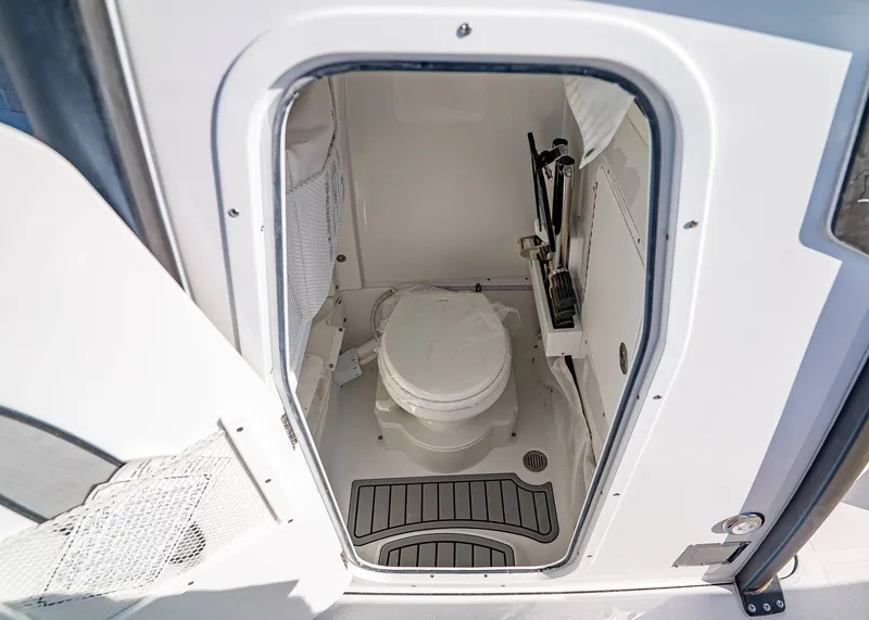 Slide: The Image of 2026 Sea Hunt Ultra 255 SE boat interior with compact marine toilet. - 23